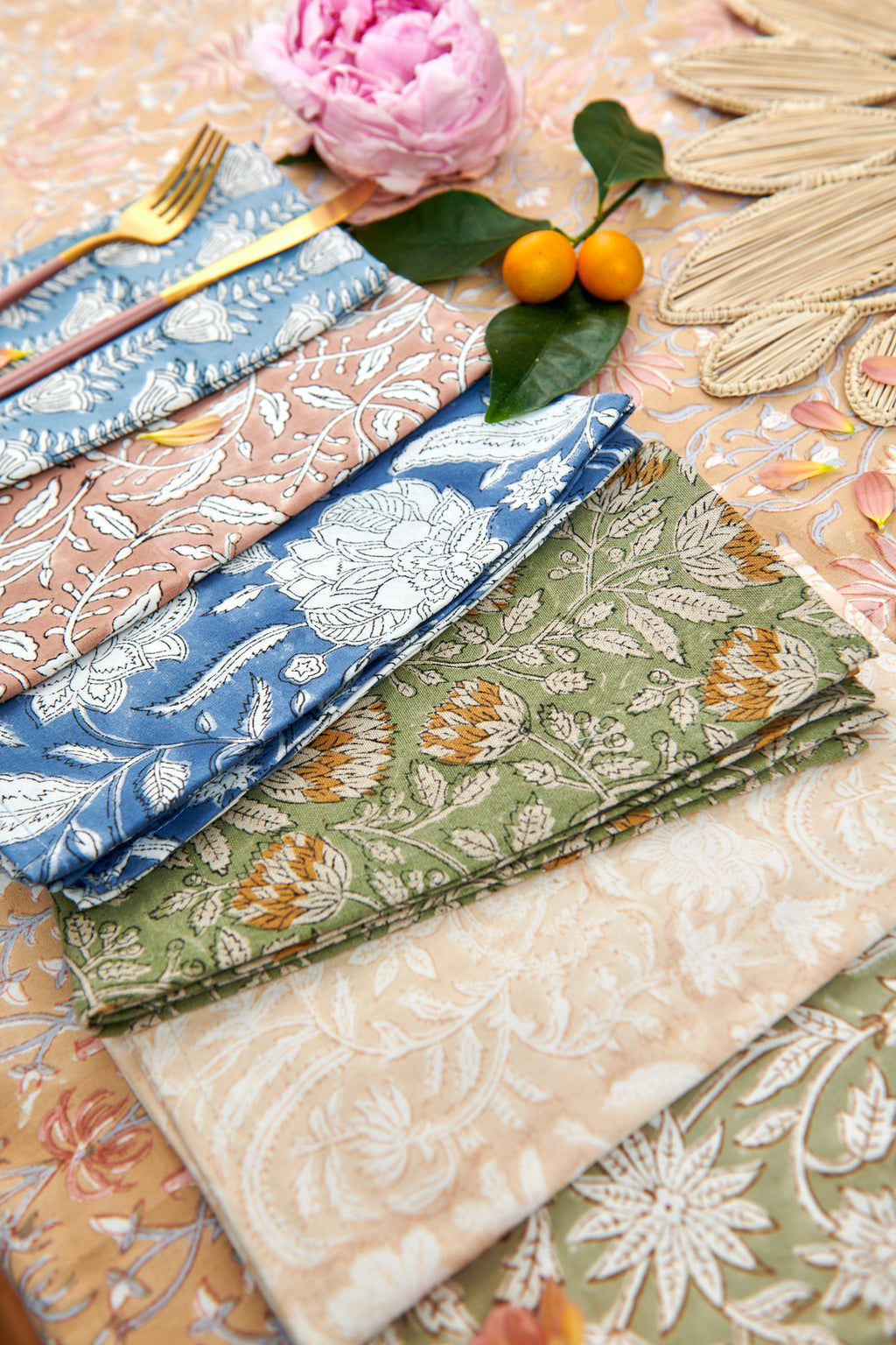 Decorative table setting with a floral napkin ring, pink flowers, and a patterned plate.